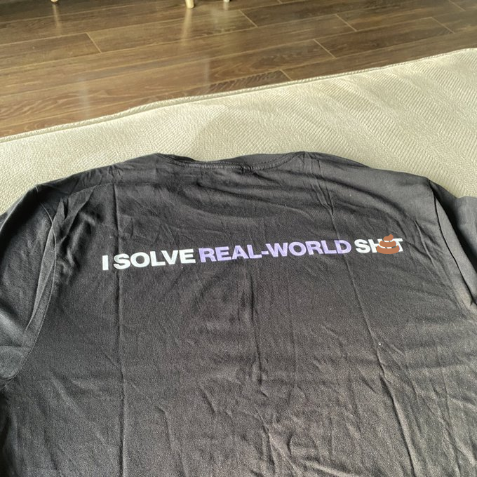 gray t-shirt with text that says I SOLVE REAL-WORLD SH💩T