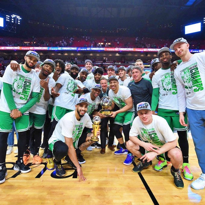 Boston Celtics com o troféu Bob Cousy (ex jogador do Celtics) e Jayson Tatum com o troféu Larry Bird (ex jogador Celta)