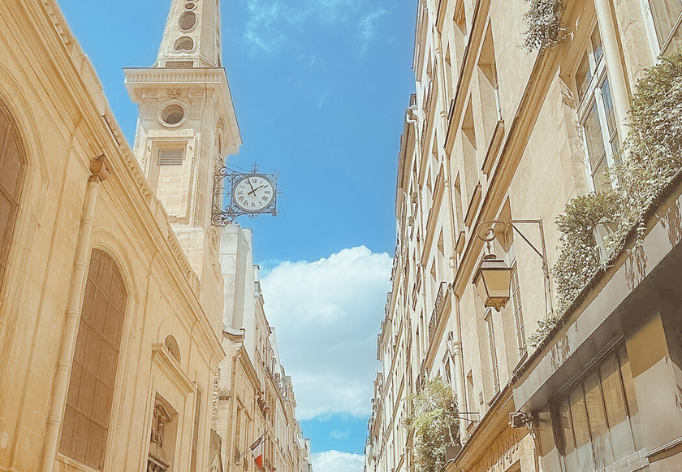 church with spire and clock on ile saint louis paris