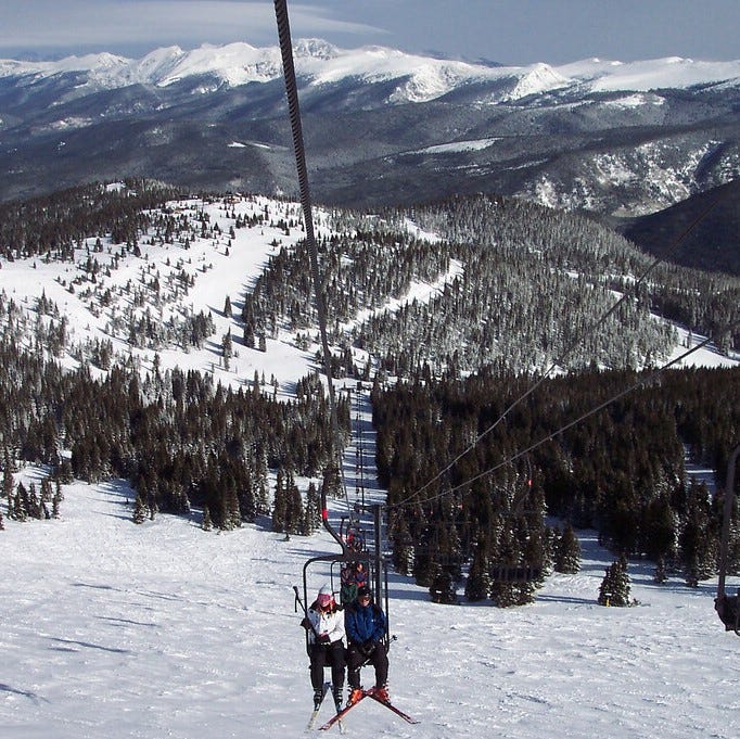 Two people on a gondola up one of the trails in Winter Park, Colorado.