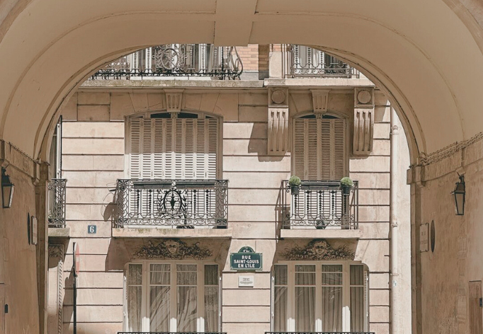 archway with building and balconies on ile saint louis paris