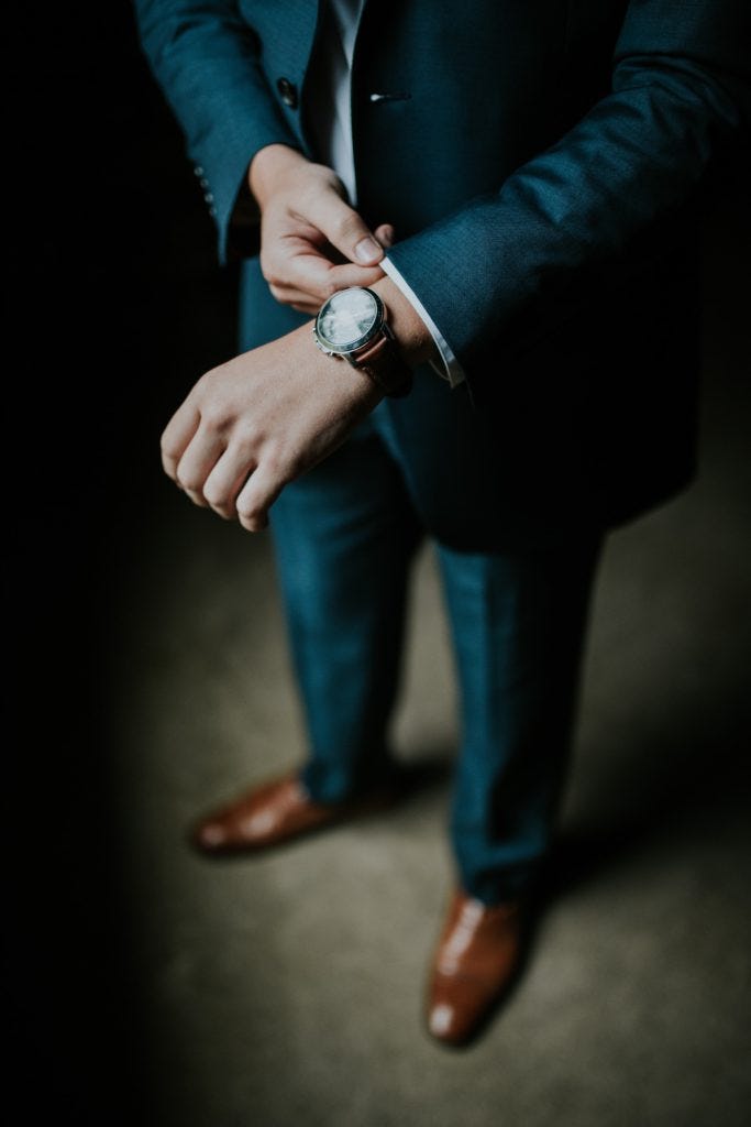 man-in-suit-checking-his-watch