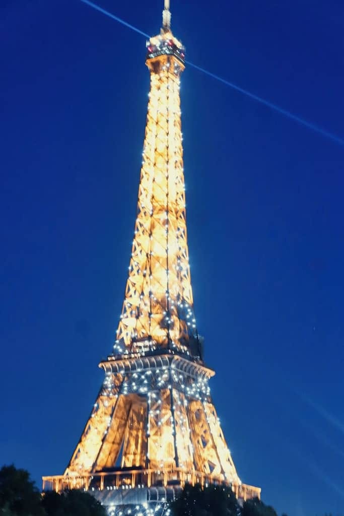 The eiffel tower is lit up at night.