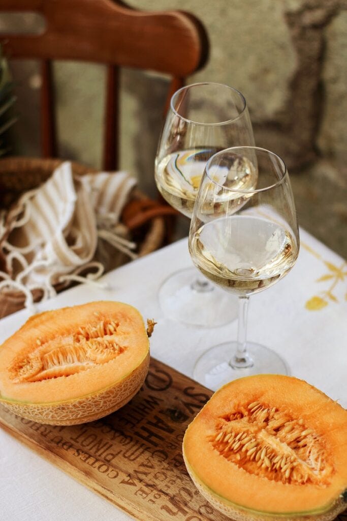 pepene galben tăiat în felii lângă un pahar de vin transparent pe o masă de lemn maro