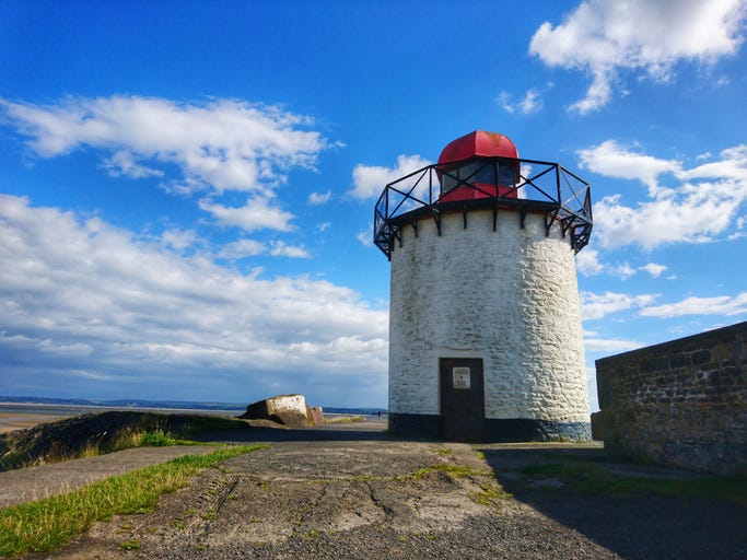 Small white squat white lighthouse with red top. Burry Port, Llanelli, Carmarthenshire, Wales.