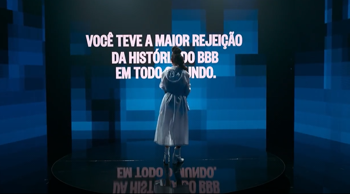 Karol lendo os dizeres no telão “você teve a maior rejeição da história do BBB em todo o mundo.”