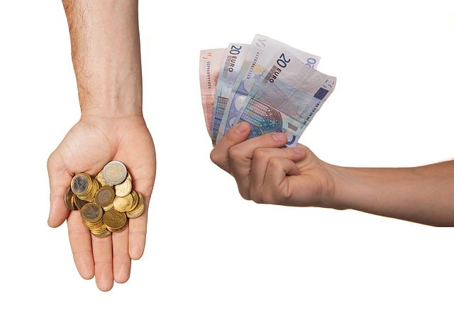 Two human hands holding cash
