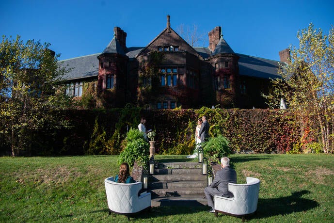 Bride and groom stand before their parents, the only guests in attendance at a 2020 Covid Wedding.