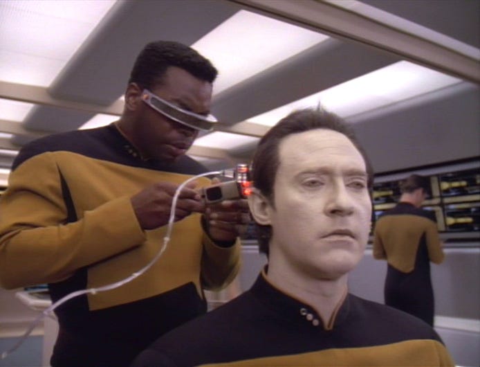 Geordi LaForge doing diagnostics on Data on Star Trek