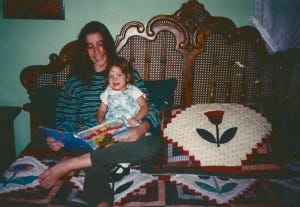 Lisa R., at the age of three, being read a bedtime story by her mother.