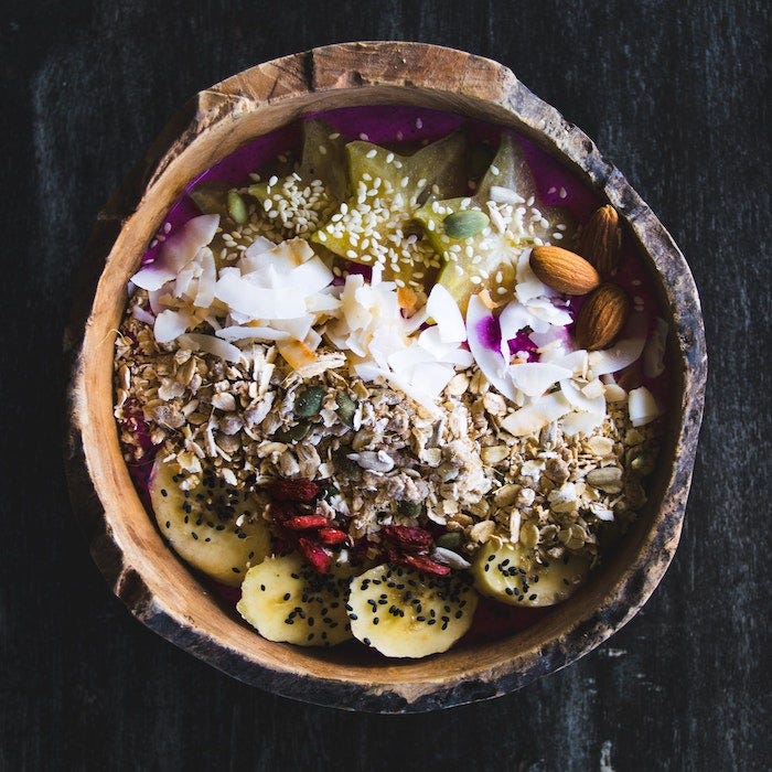 Bowl of healthy food with banana, coconut, nuts, seeds