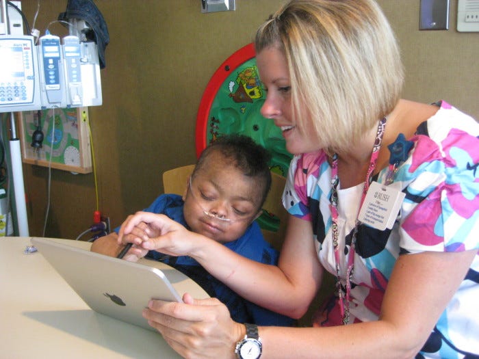 Nevin Jamason with Kristy Rowe and her iPad. (childrendaytons.org)
