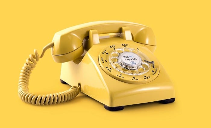 A yellow landline telephone on yellow background.