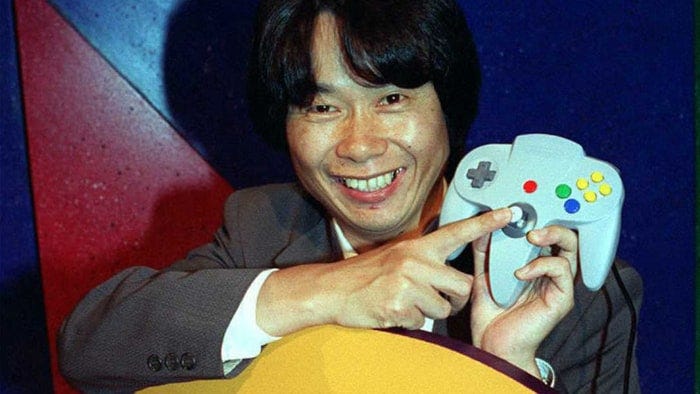 Miyamoto showing the analog stick of the N-64 controller.