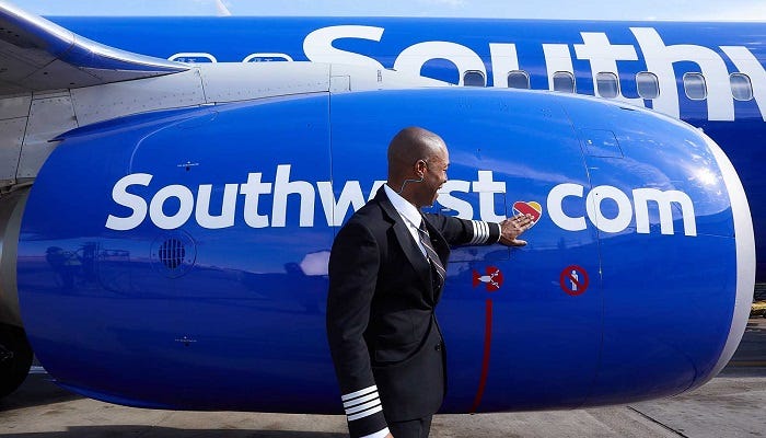 A Southwest Airlines employee touching the heart logo on the airplane