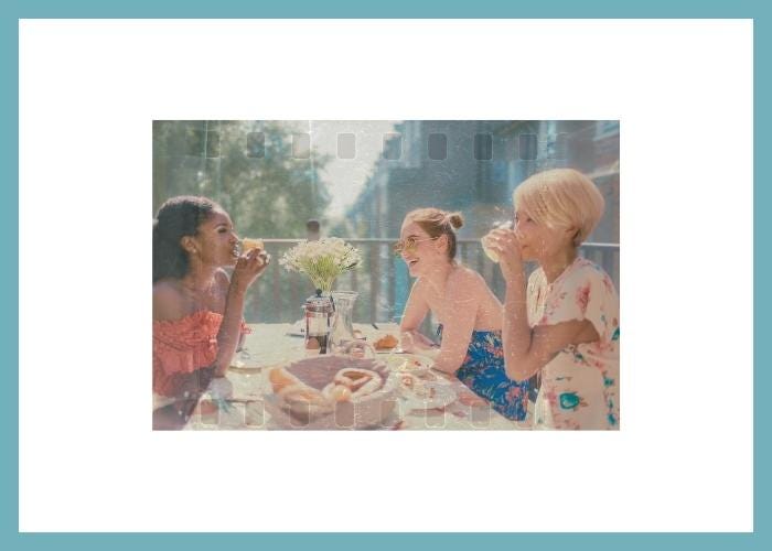 three women enjoying an outdoor brunch on a sunny day in an urban setting