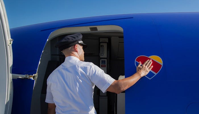 An employee touching the heart logo on an airplane