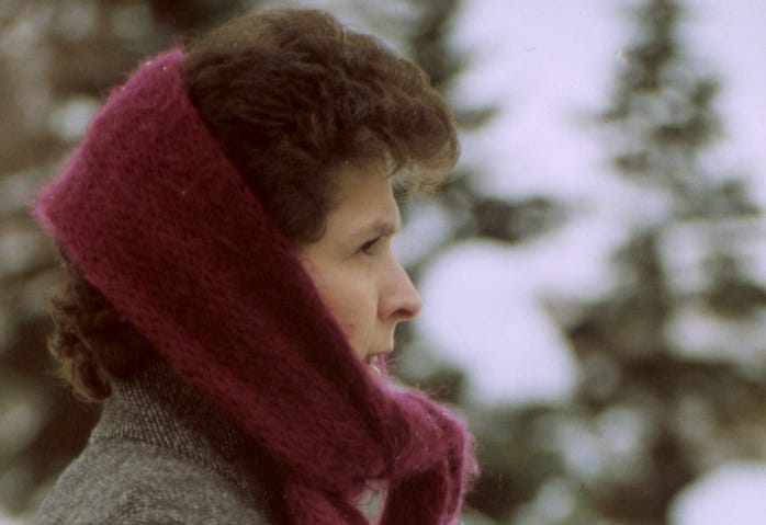 Photo of my sister, outside in the snow, wearing a red scarf and facing right in profile