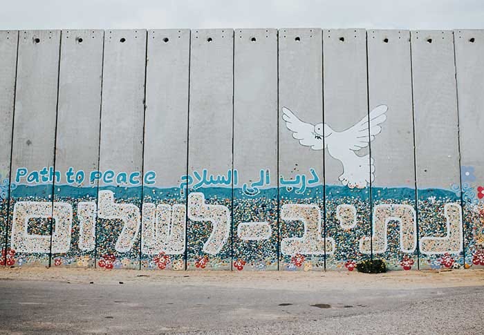 “Path to peace” graffiti on a wall at Netiv HaAsara facing the Gaza border. Photo by Cole Keister on Unsplash (public domain).