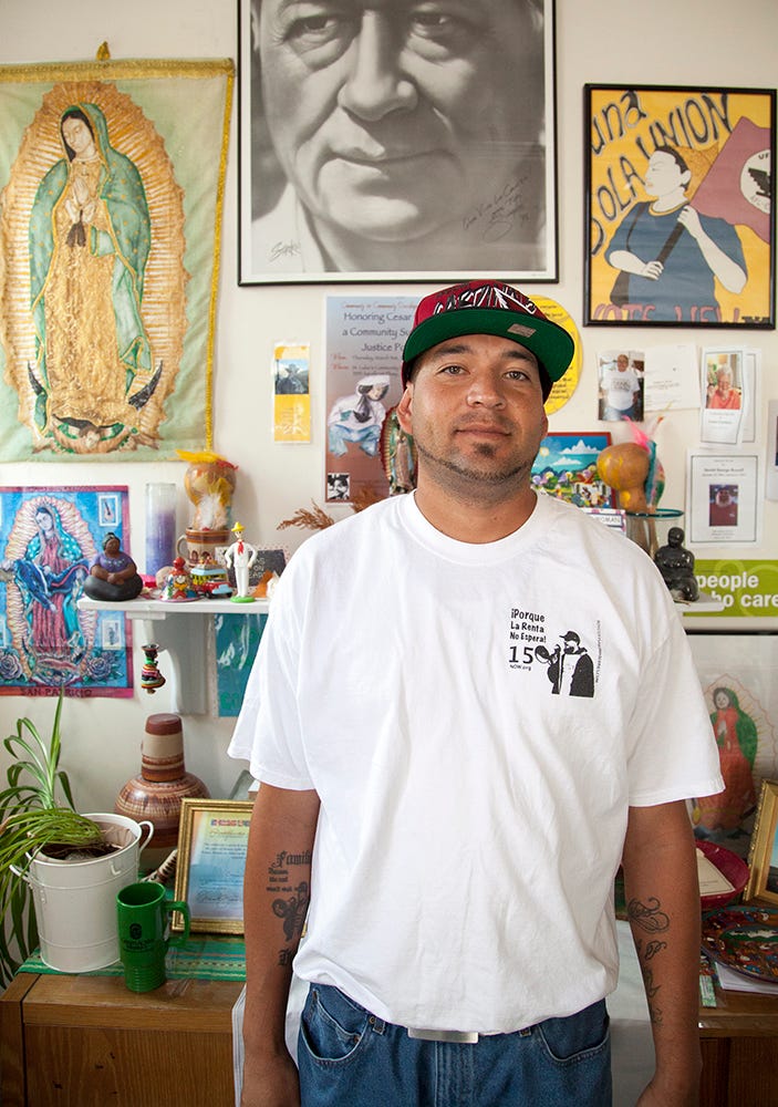 Ramon Torres stands in front of a Cesar Chavez shrine.