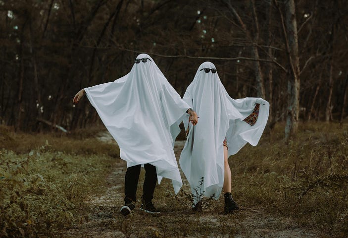 A couple dressed as ghosts.