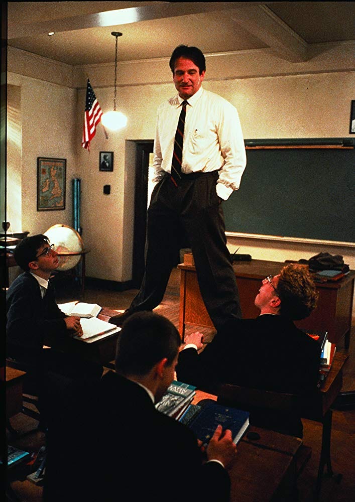 Teacher standing on students’ desks