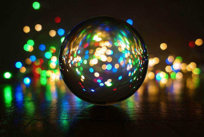 Color lights shine from behind a circular orb or crystal ball