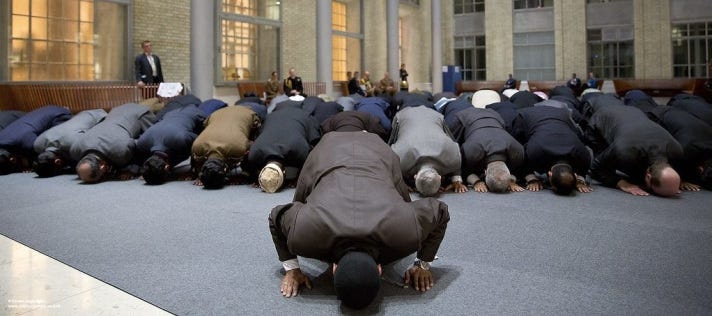 Muslim men on the floor praying