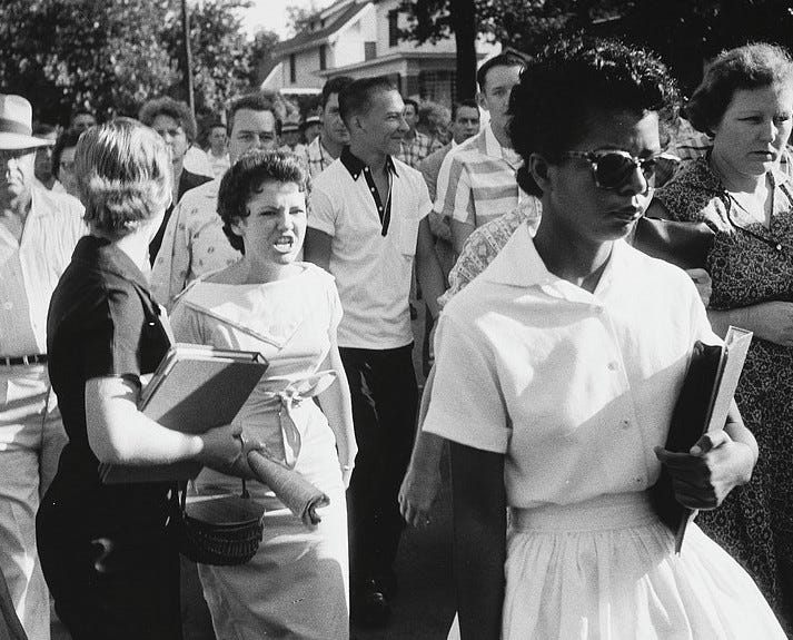 Image of Elizabeth Eckford attempting to enter Little Rock Arkansas High School while being accosted by white students who are trying to block her attendance.