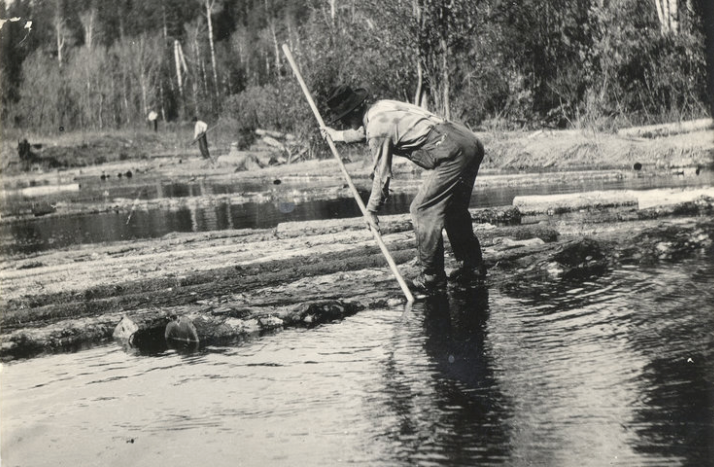 Log Operator guiding logs through a river. Photo credit: Superior National Forest [CC BY 2.0 (https://creativecommons.org/lic