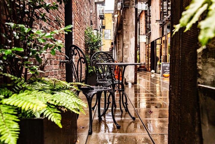 A cafe table on a rainy street.