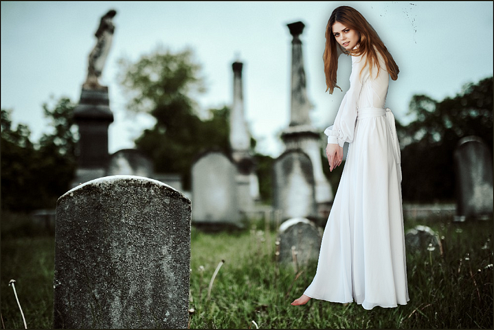 Picture of a girl in a white flowing dress in a cemetery