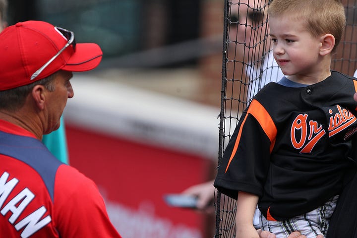 Washington Nationals manager Jim Riggleman (5) and an Orioles fan