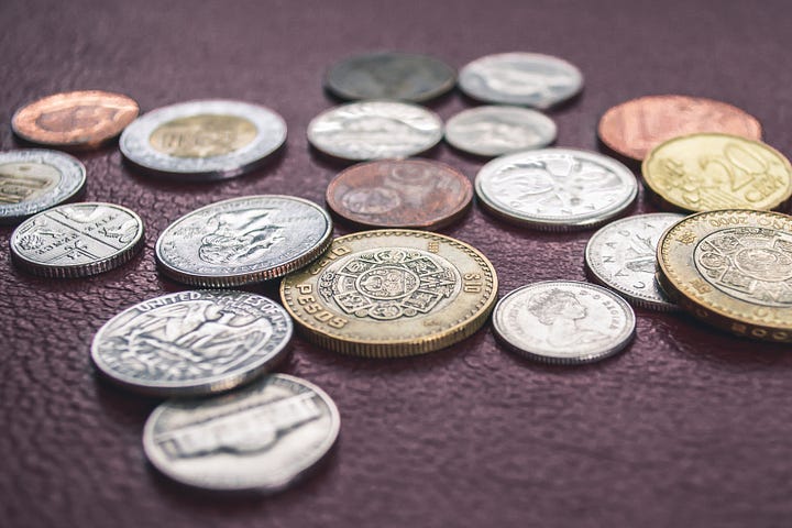 Quarters, Nickels and dimes laying on a table.