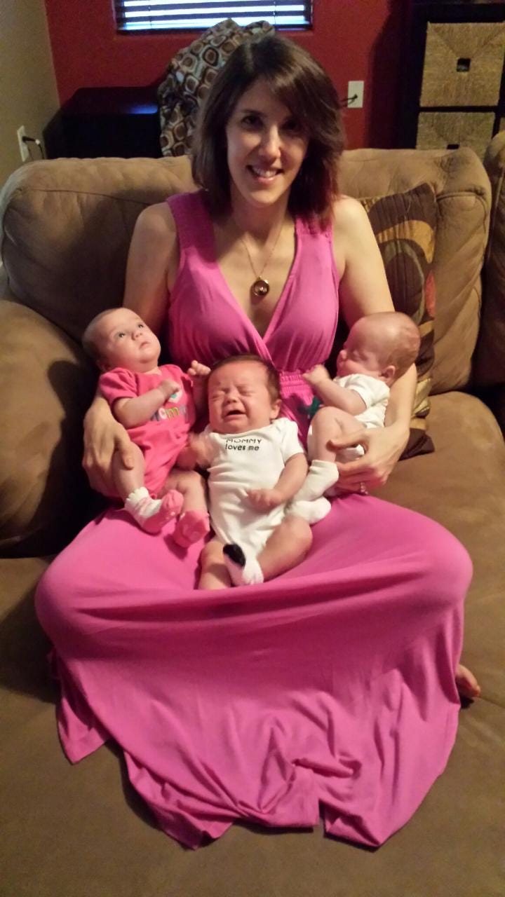 A triplet mother poses with her infant triplets on her first Mother’s Day.