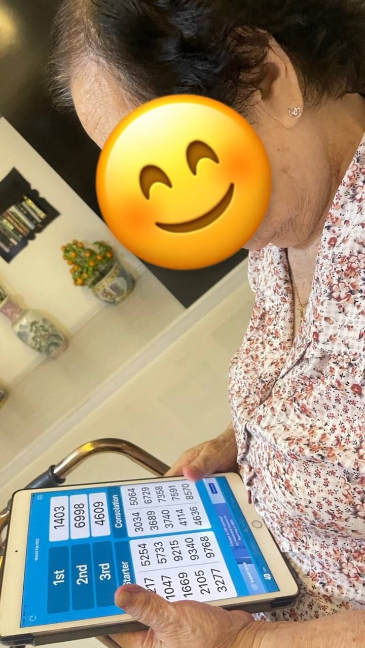 My paternal grandmother looking at 4D (another form of lottery) results, which is a popular pastime for elderly in Singapore