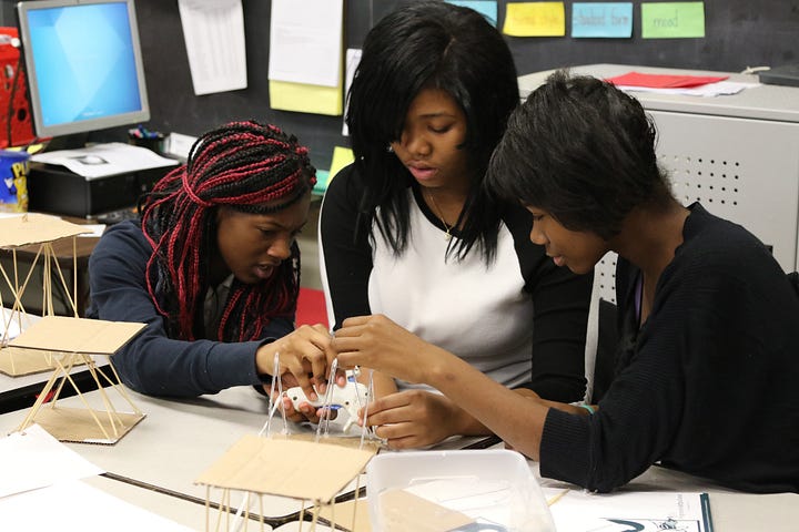 Students in the eighth grade class at Michael R. White STEM School build one of their structures design to withstand forces exerted from weight and vibration.