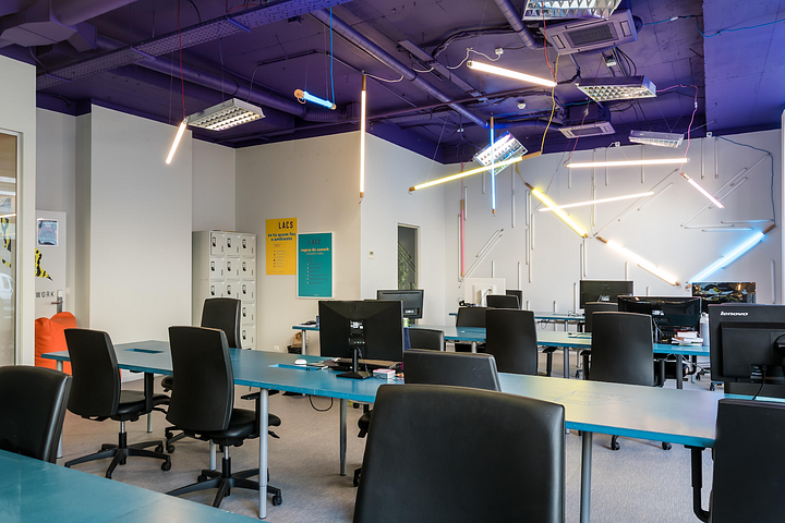Colourful space at LACS equipped with multiple chairs at shared desks 