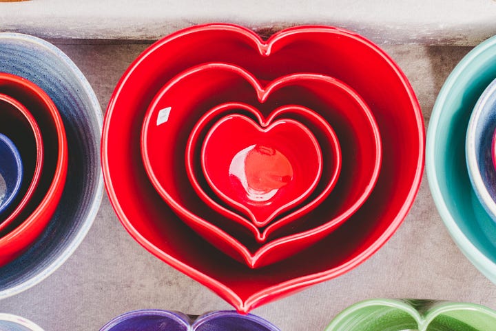 A set of red, heart-shaped nesting ceramic bowls.