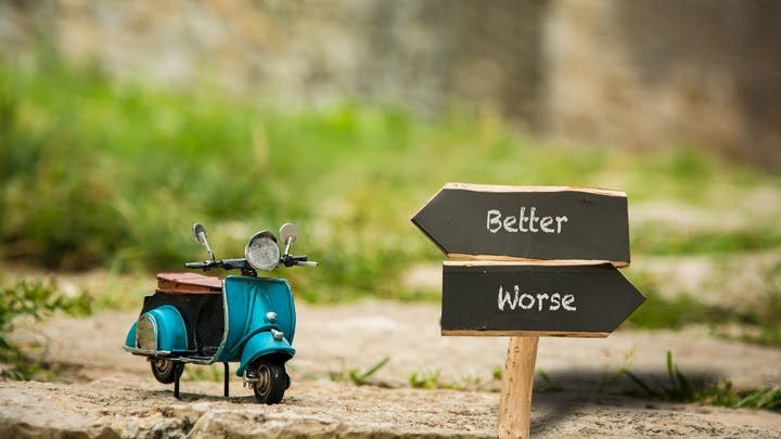 A road with a motorcycle, showing “Better” and “Worse” signs