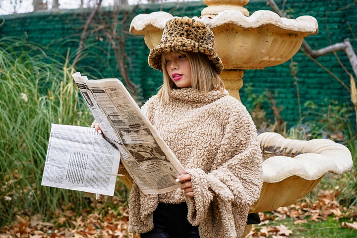 a woman reading a newspaper near a fountain