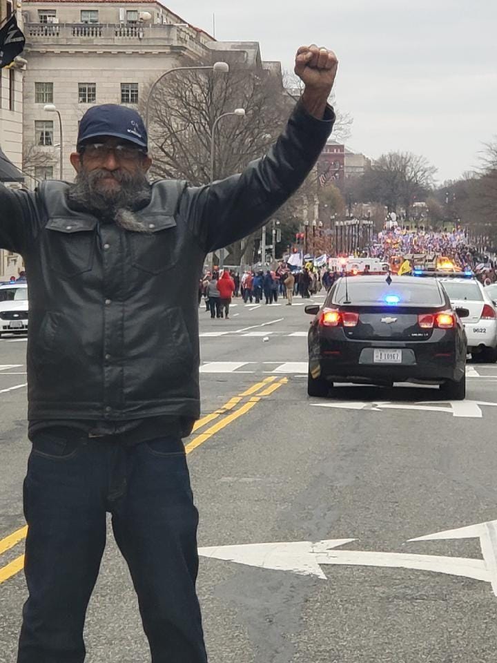Ed Vallejo raising his hands triumphantly on a Washington DC street on January 6th
