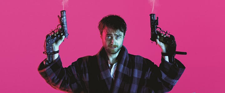 Image of Daniel Radcliffe duel wielding guns attached to his hands against a pink background.