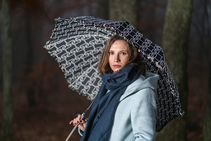 Woman walking with umbrella. Shades of blue.