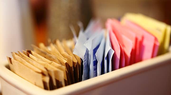 Different colorful packets of artificial sweeteners and sugars