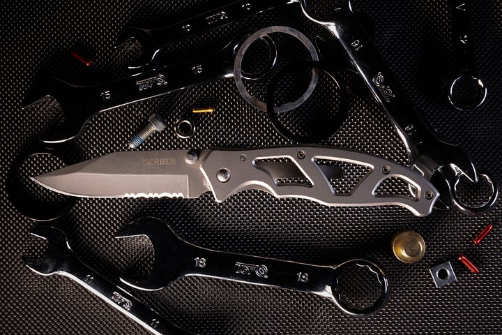 A pocket knife surrounded by bolt, screws and spanners