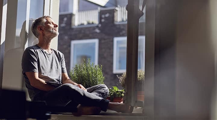 Man getting vitamin D from the sunshine coming through window