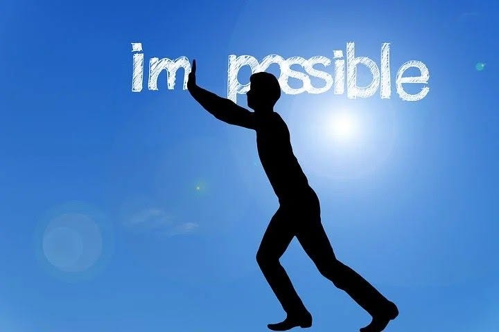 A man trying to push away letter “im” from the word “impossible”.