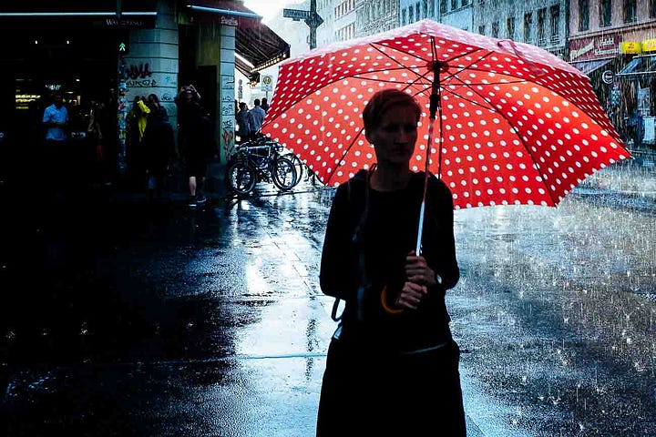 Woman on street with umbrella Image by Martin U Waltz (©)
