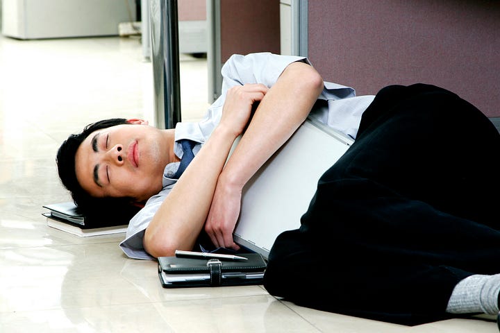 A photo of a businessman asleep on the floor.